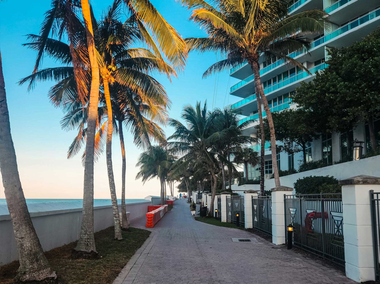Palm-lined beachfront walkway running past oceanfront buildings at Bal Harbour