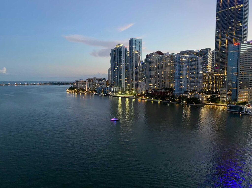 Aerial of Brickell at dusk with the lit skyline above Biscayne Bay