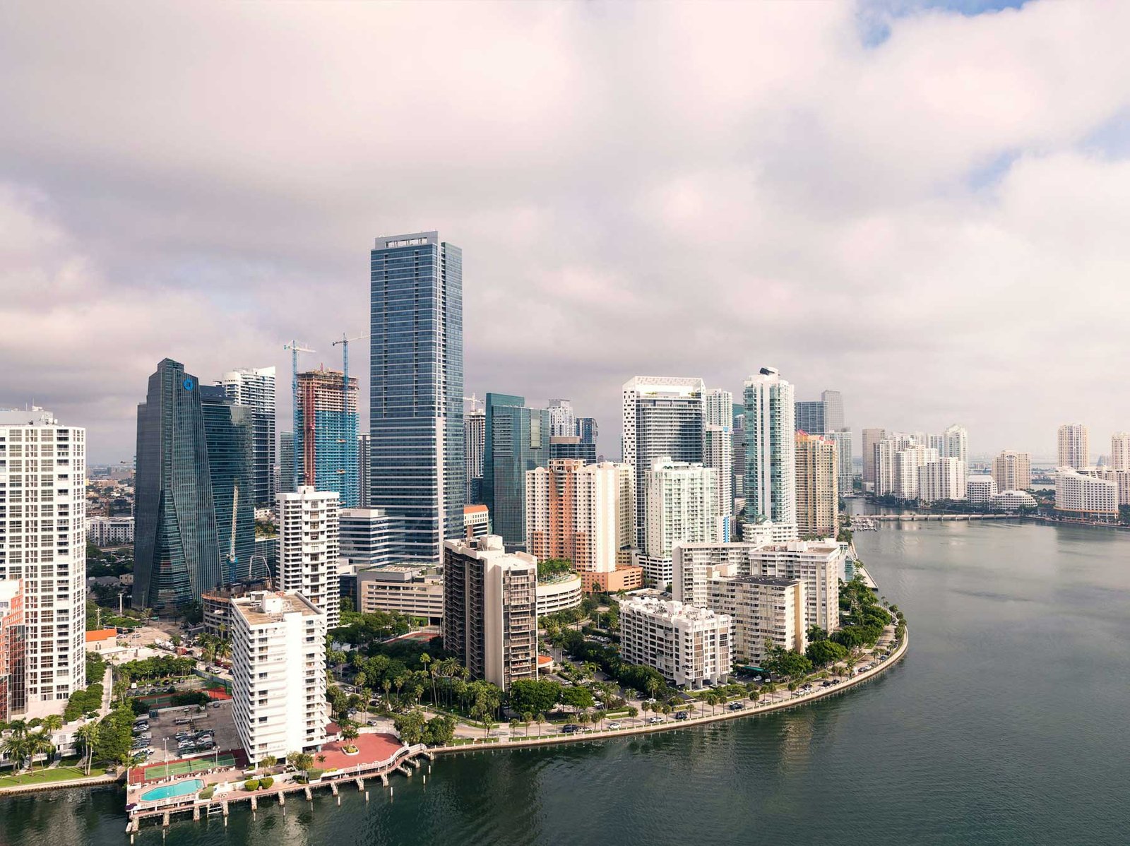 - Brickell Condos Aerial of Brickell Key and the Brickell peninsula with construction cranes among the towers