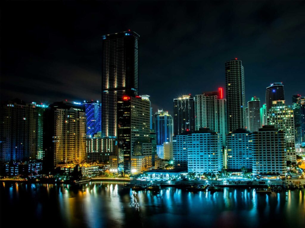 Brickell skyline at night with lit towers reflected in the water