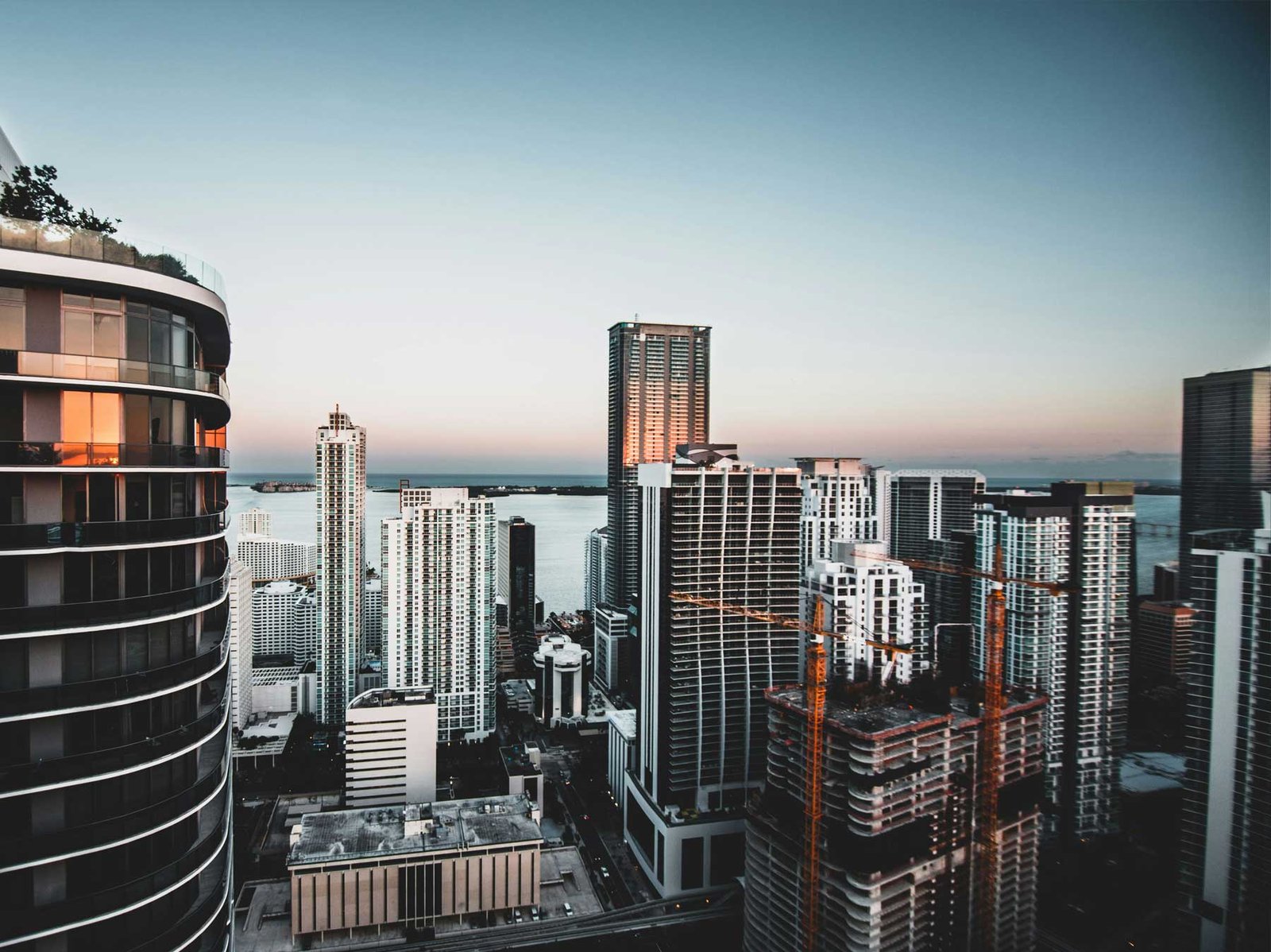 - Brickell Condos High vantage over Brickell towers and construction cranes at dusk