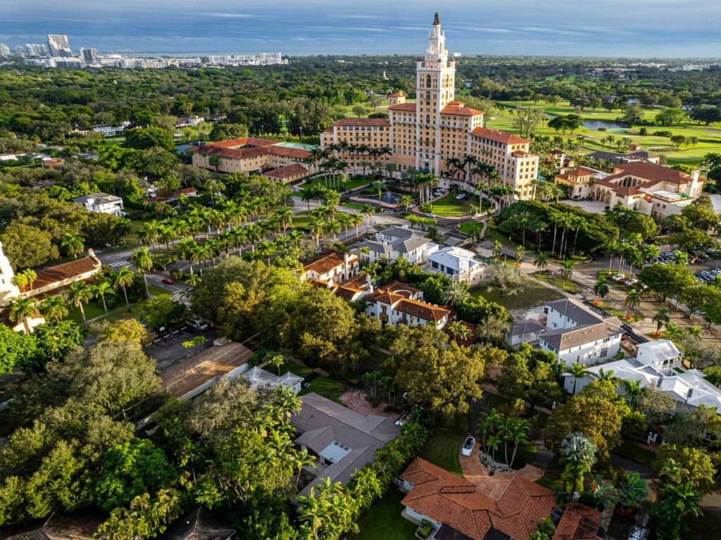- Coral Gables Aerial view over Coral Gables with the Biltmore tower, golf course and tile-roofed houses under the tree canopy