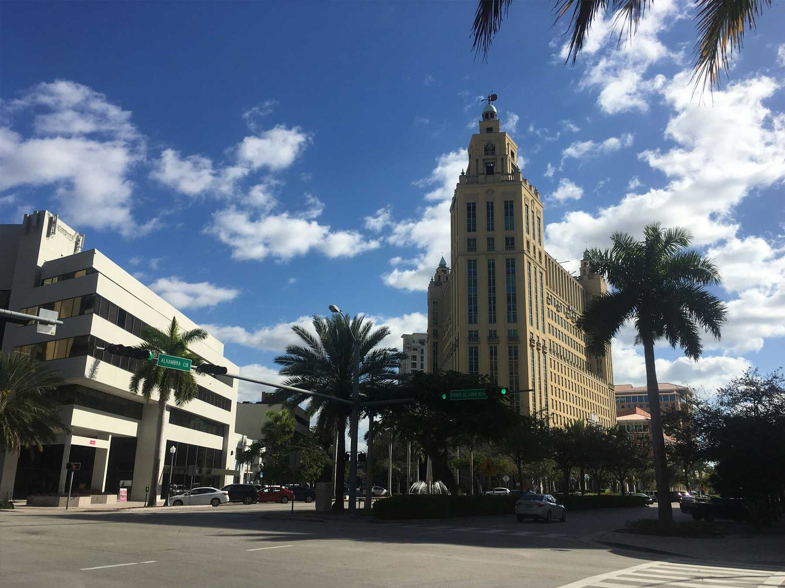- Coral Gables Coral Gables streetscape with the Colonnade tower against a cloudy sky
