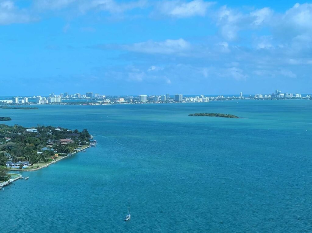 - Key Biscayne Aerial over Biscayne Bay from Key Biscayne, with waterfront homes, turquoise shallows and the Miami skyline in the distance