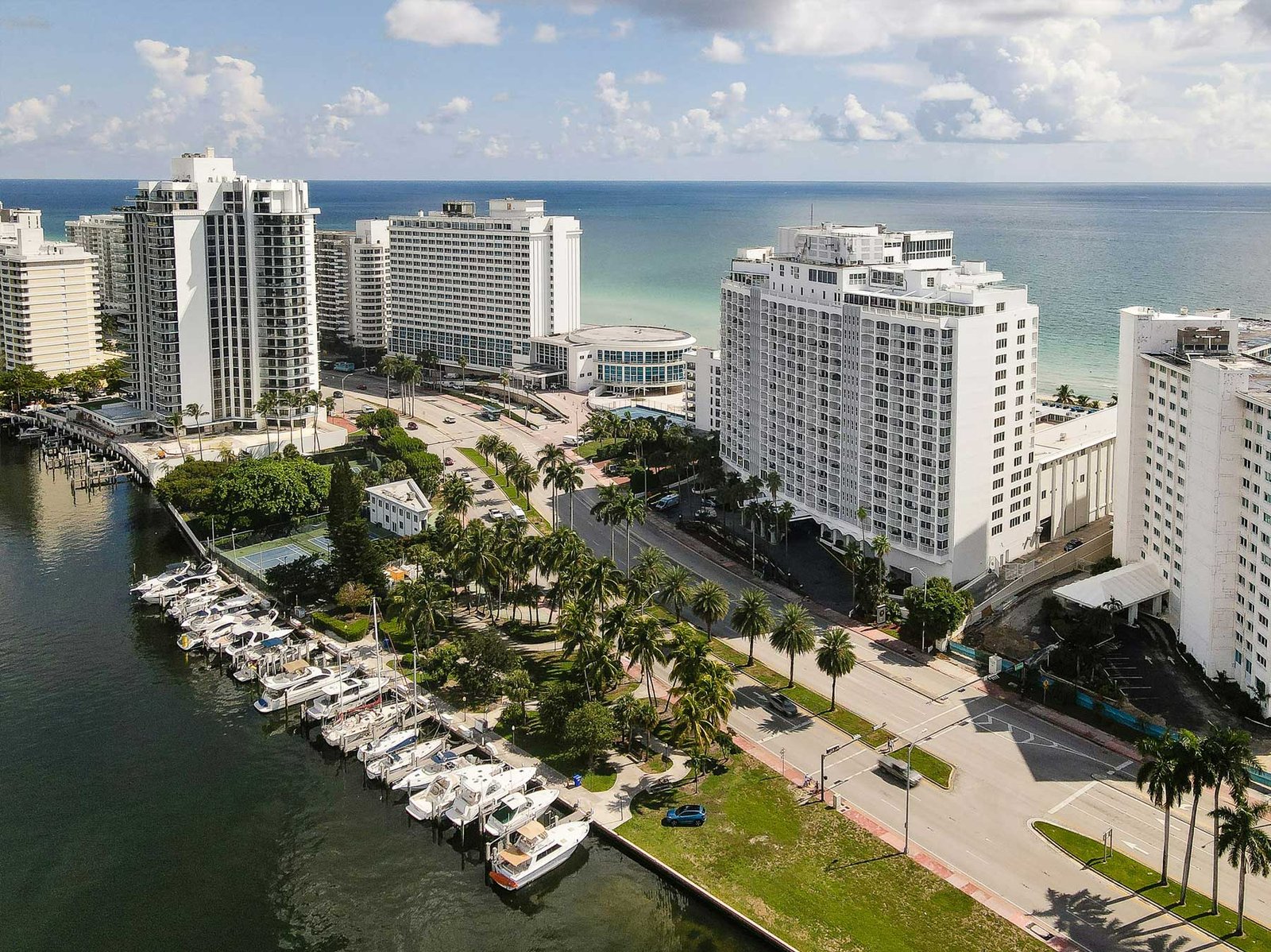 Aerial of a Miami Beach marina with yachts and oceanfront buildings behind