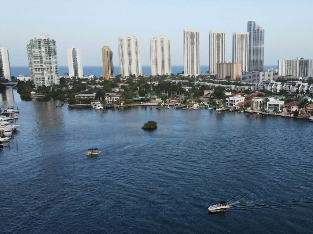Aerial of waterfront homes with private docks on an Intracoastal waterway, oceanfront towers behind