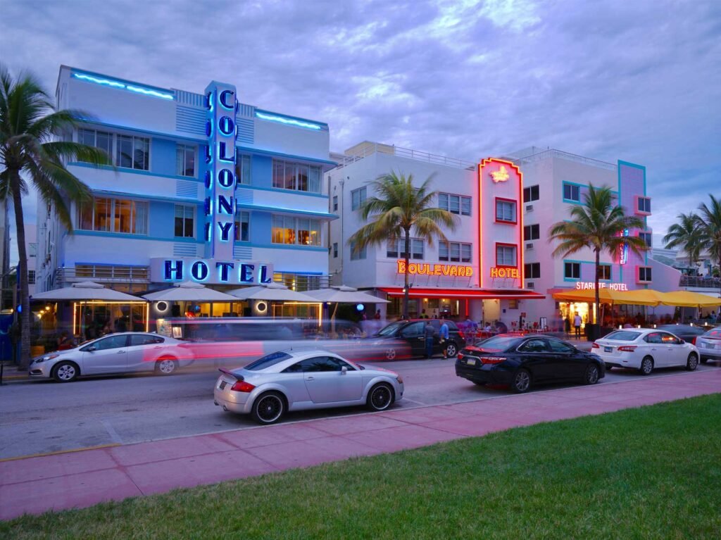 Neon-lit Art Deco hotels on Ocean Drive at dusk, South Beach