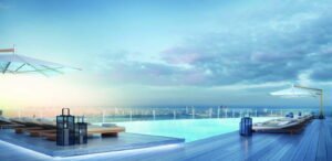 The tower at the waterfront at dusk, palms and a moored superyacht — developer rendering