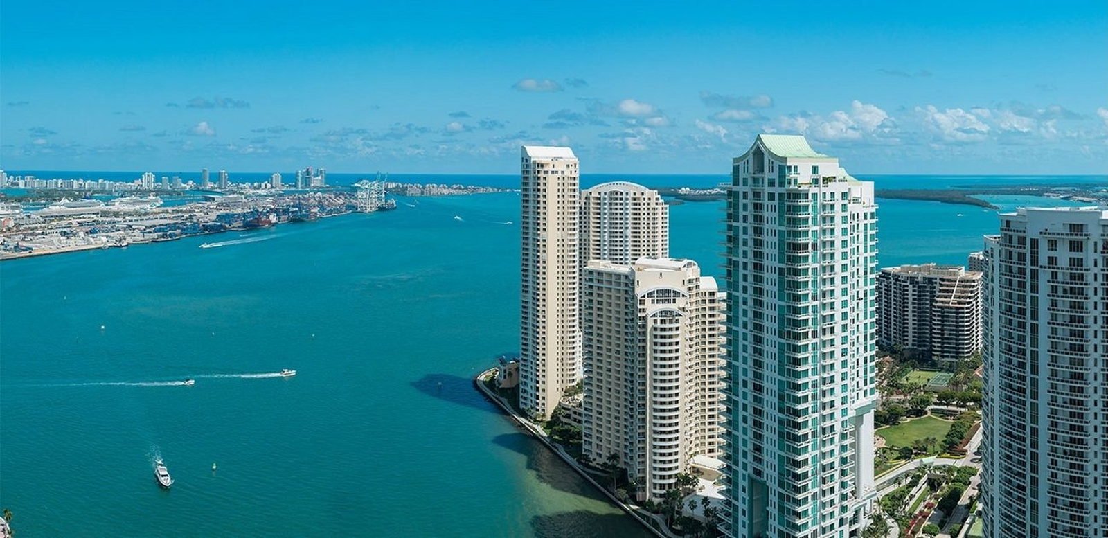 Aerial over Brickell Key with the mouth of the Miami River, the Port of Miami and South Beach beyond