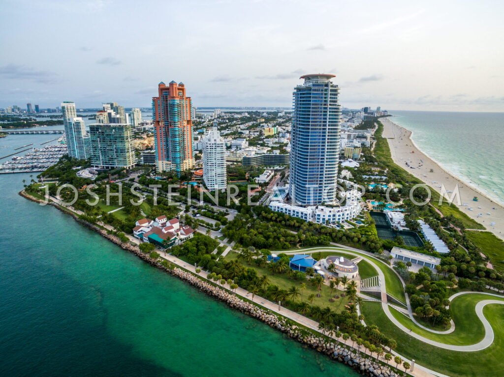 Aerial view of South of Fifth, Miami Beach — Continuum, Portofino Tower, Murano Grande and Apogee above South Pointe Park, with the Miami Beach Marina to the west and South Beach beyond
