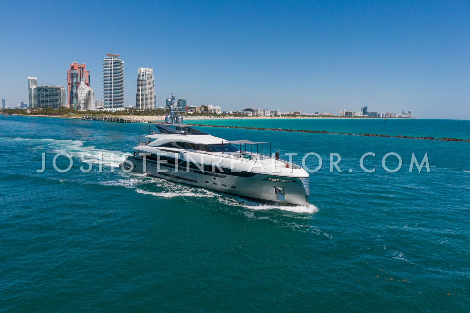 A superyacht outbound through Government Cut past South Pointe, with the South of Fifth towers behind