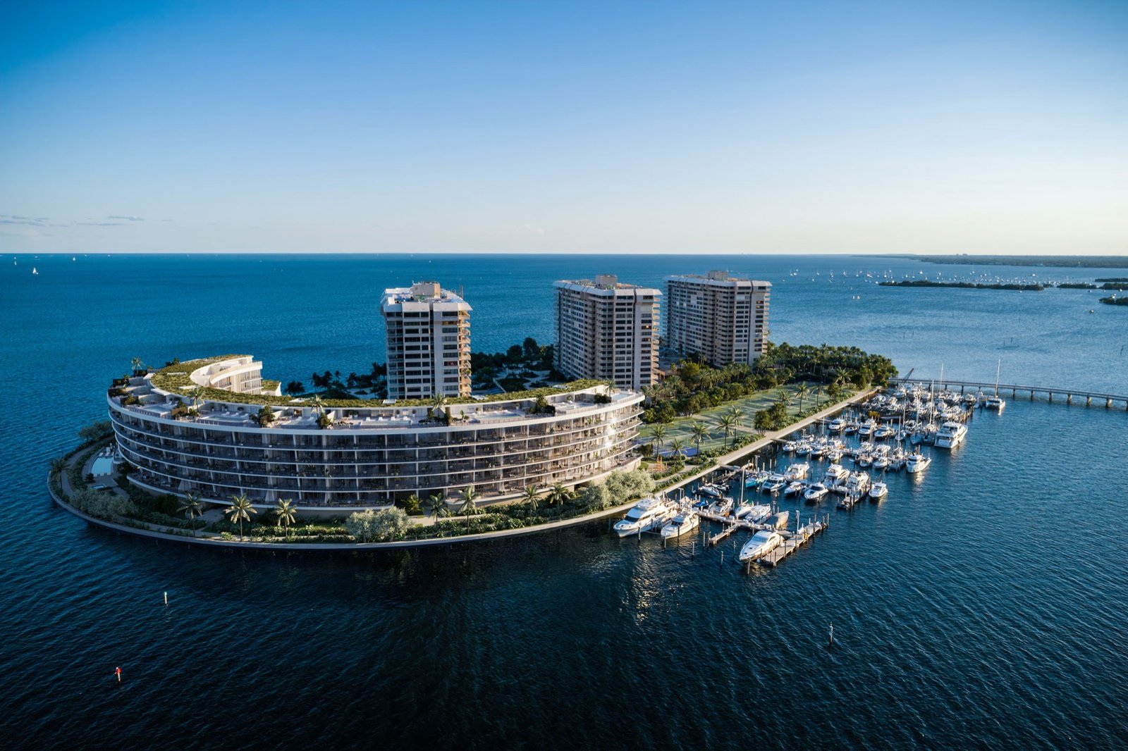 Vita at Grove Isle, Coconut Grove, Miami - exterior rendering of the curved building facade at dusk, developer rendering